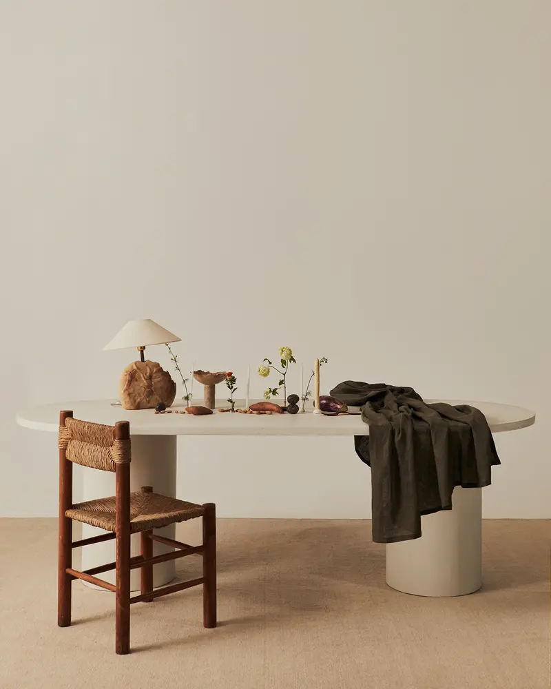 Mesa de comedor Reye ovalada de microcemento con patas de roble natural